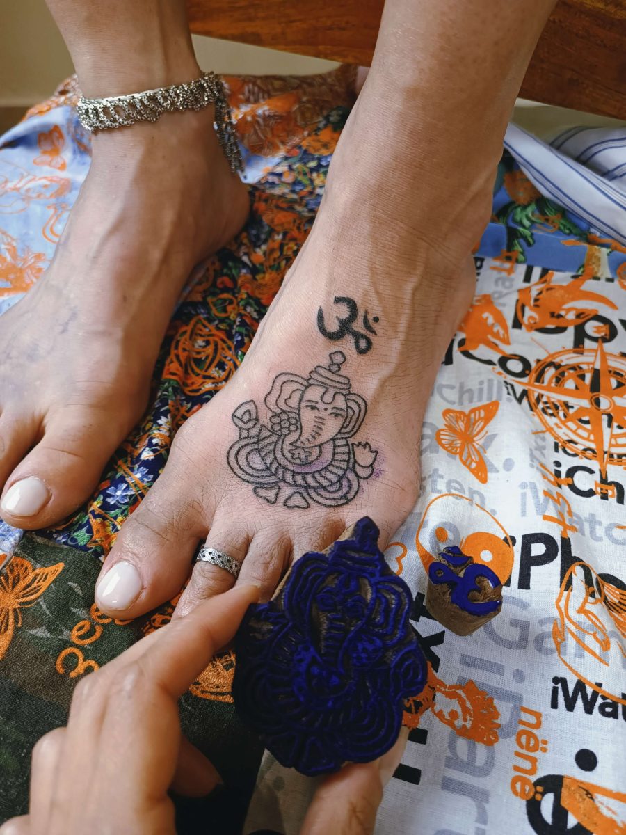 tatuaggio eseguito a macchinetta, con disegno applicato da woodblock proveniente dall'India, raffigurante la divinità Ganesh e il mantra Aum